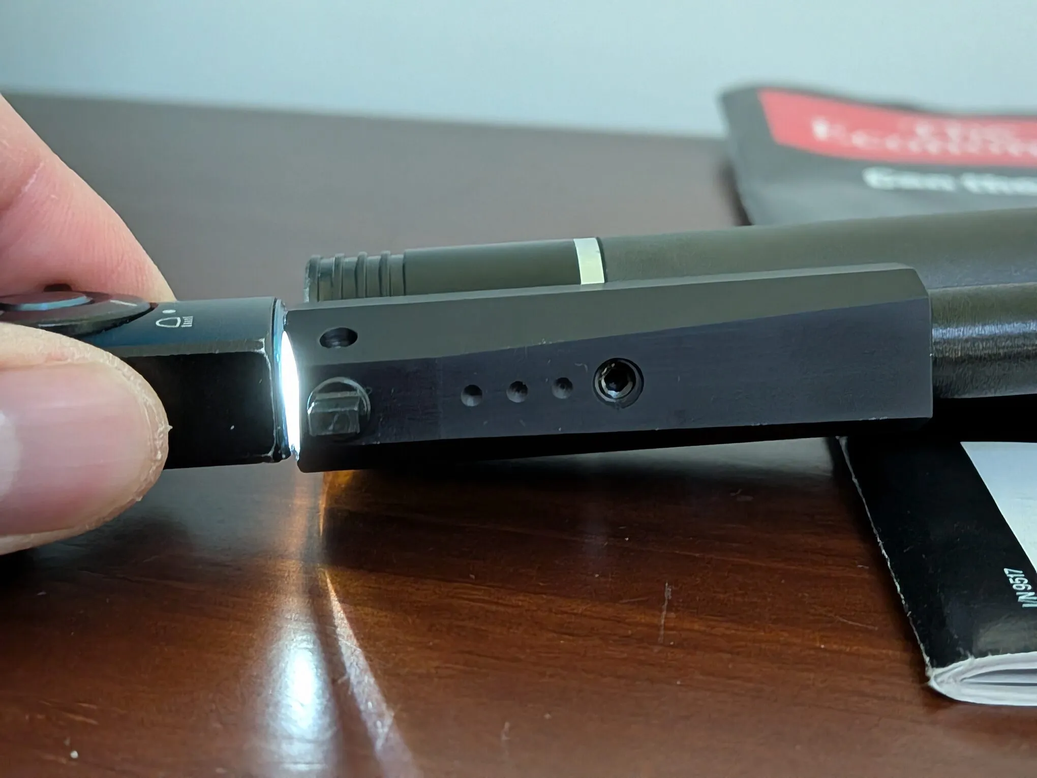 Close-up of three dimples and a recessed screw on the front sight housing