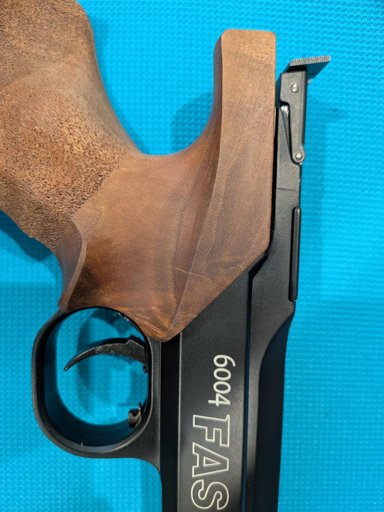 Left-side contour detail showing the curved wooden grip meeting the black frame