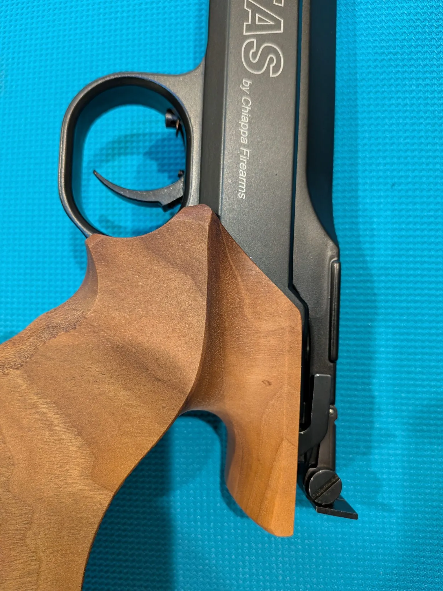 Right-side contour detail showing the transition from the wooden grip to the frame and trigger guard