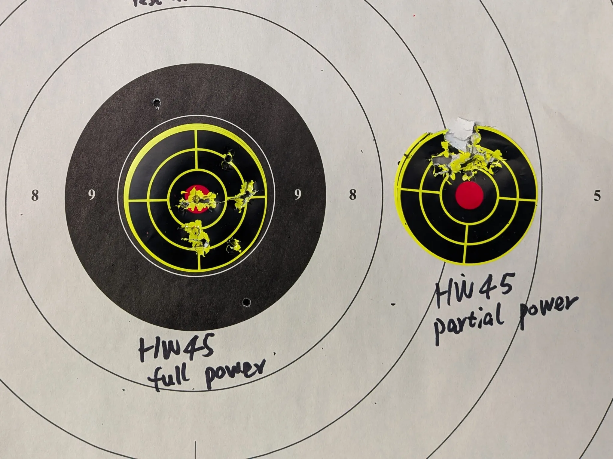 HW45 target results, with the more spread-out full-power group on the left and a more compact low-power group above the aiming point on the right