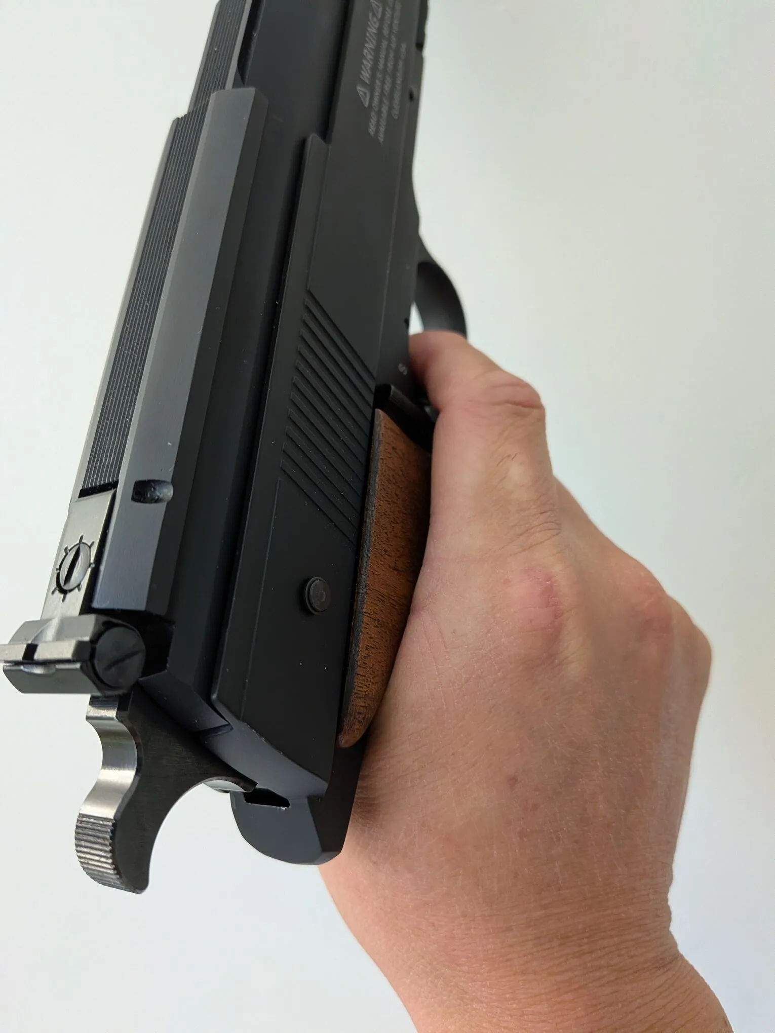 HW75 held in the hand, showing the fit around the web between the thumb and index finger