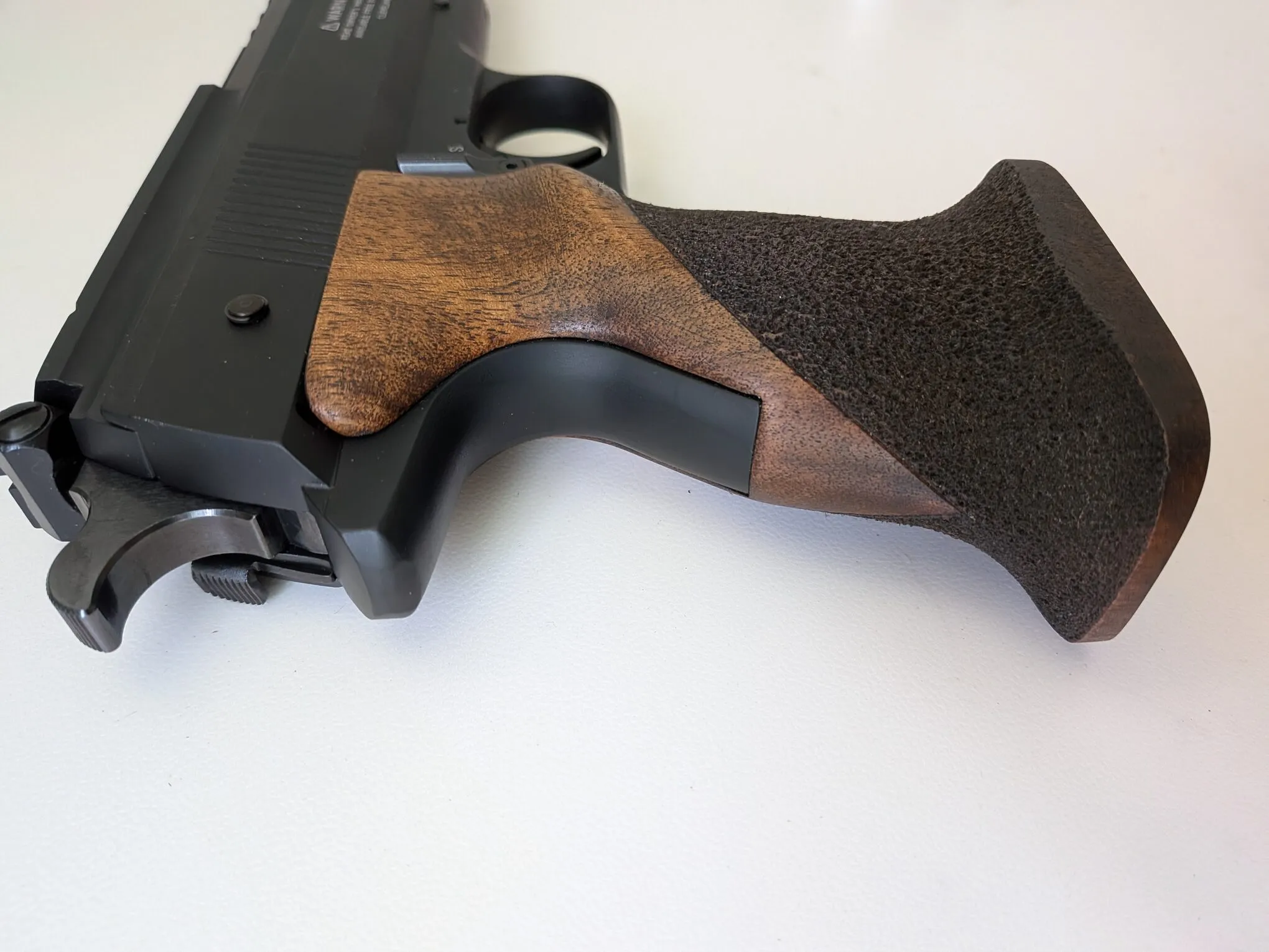 Close-up of the HW75 walnut grip, showing its textured surface and upper contours