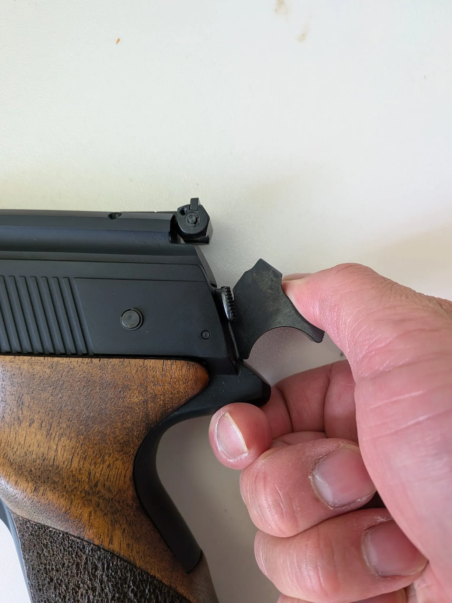 Pulling the HW75 hammer backward to cock it
