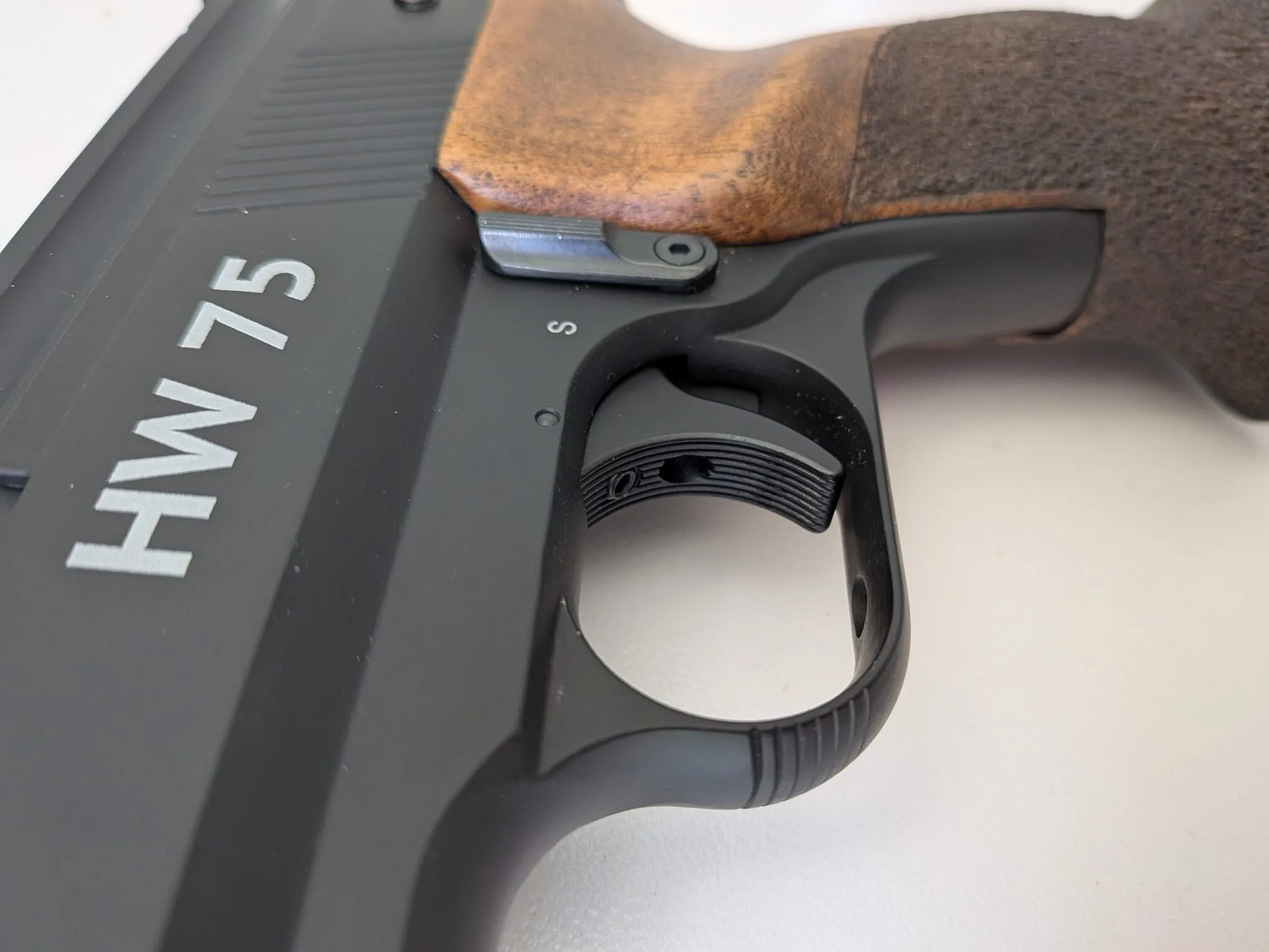 Close-up of the HW75’s two-stage match trigger, showing its broad, grooved blade