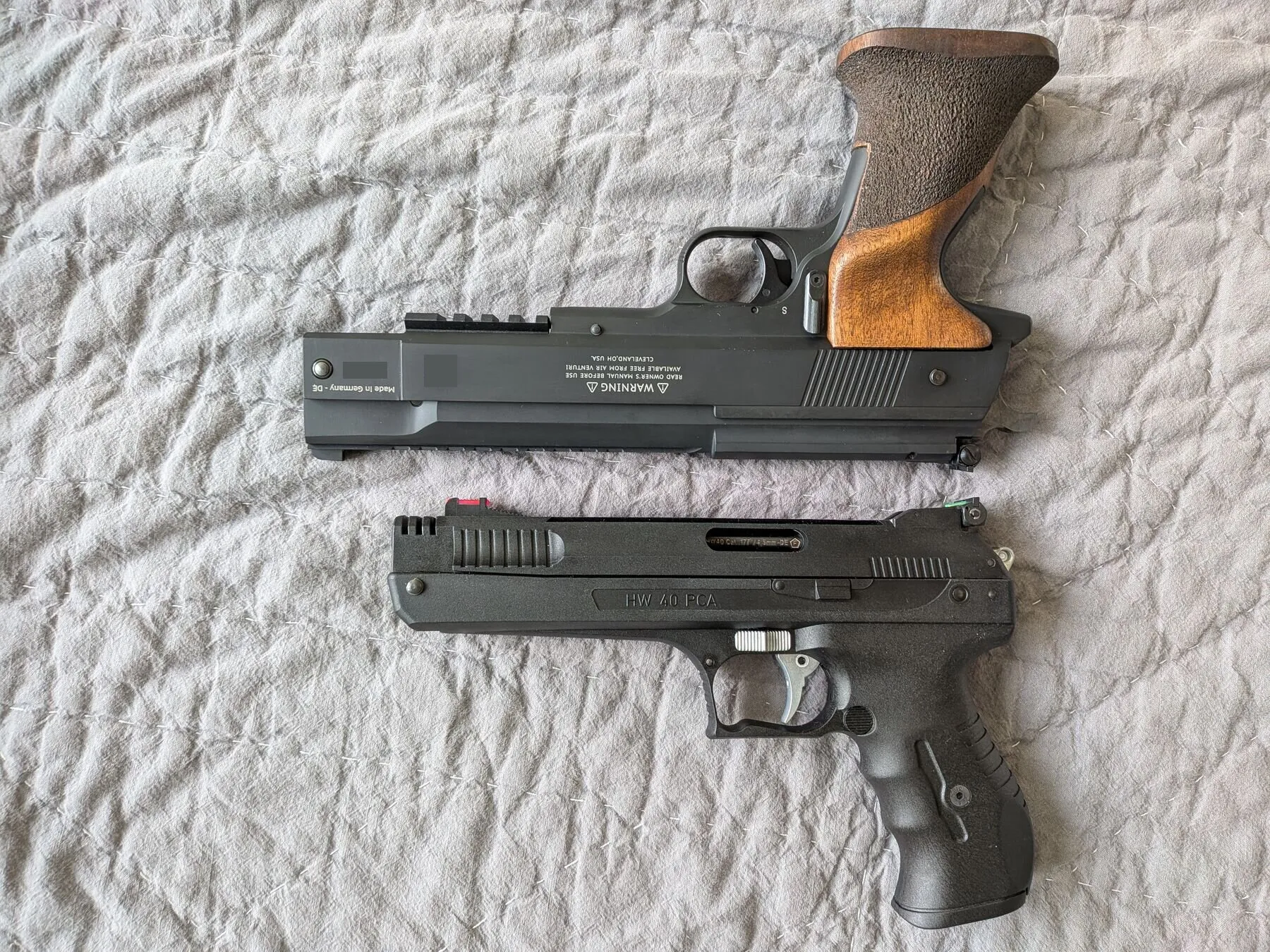 HW75 above the smaller HW40, comparing the walnut grip and metal frame with the HW40’s polymer exterior